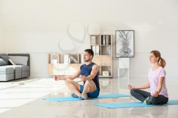 Happy couple in love meditating at home�