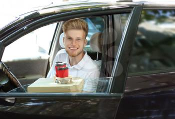 Worker of food delivery service in car�