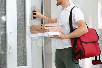 Worker of food delivery service ringing the doorbell�