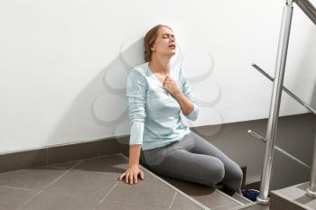 Woman having panic attack in the stairway�