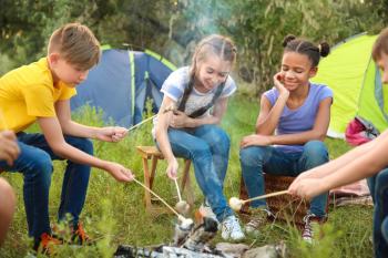 Children roasting mushrooms on fire at summer camp�
