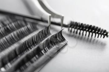 Set of eyelash extensions on grey background, closeup�