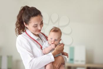 Pediatrician with cute little baby in clinic�
