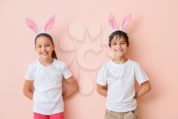 Happy little children wearing bunny ears on color background�
