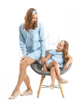 Portrait of beautiful woman with her little daughter sitting on chair against white background�