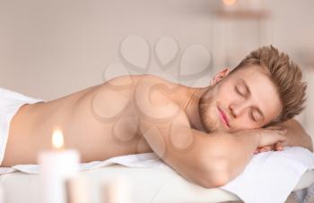 Handsome young man relaxing in spa salon�