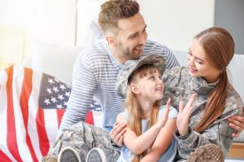 Happy female soldier with her family at home�