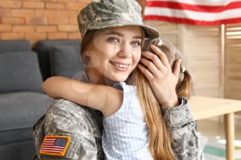 Happy female soldier with her daughter at home�