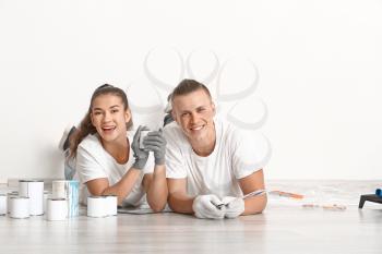 Happy young couple choosing color of paint for walls in their new house�