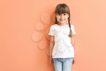 Little girl in stylish t-shirt on color background�