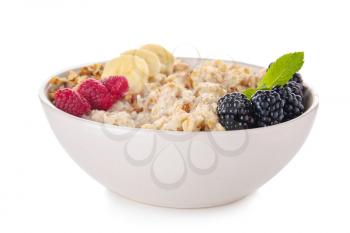 Bowl with tasty sweet oatmeal on white background�