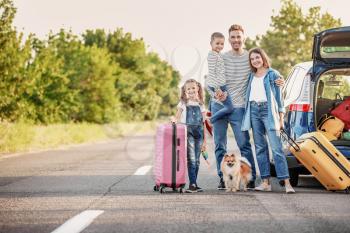 Happy family with luggage near car outdoors�