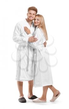 Happy young couple in bathrobes on white background�