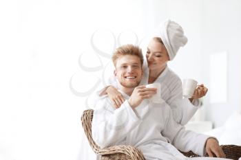 Morning of happy young couple in bathrobes at home�