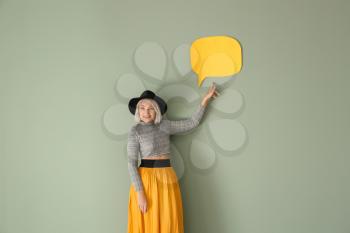 Mature woman with blank speech bubble on color background�