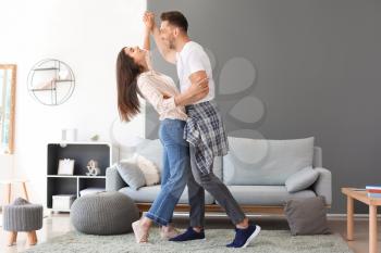 Happy young couple dancing at home�