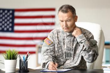 Mature male soldier writing report in headquarters building�