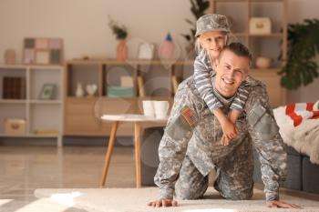 Happy military man playing with his daughter at home�