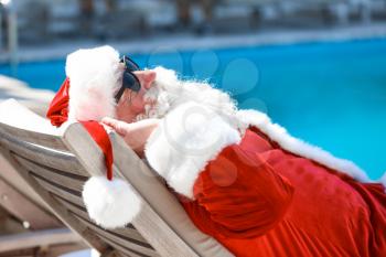 Santa Claus resting near swimming pool at resort�