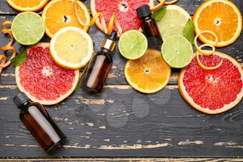 Composition with citrus essential oil on dark wooden background�