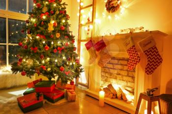 Beautifully decorated Christmas tree with gift boxes in room�