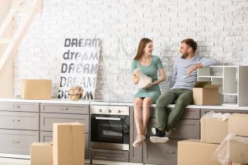 Happy young couple with belongings in their new house�