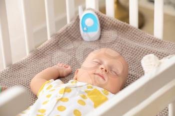Modern baby monitor in crib of cute sleeping infant�
