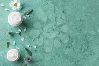 Body cream in jars on color background�