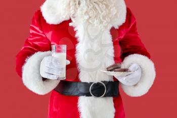Santa Claus with milk and cookies on color background, closeup�