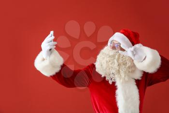 Portrait of Santa Claus taking selfie on color background�