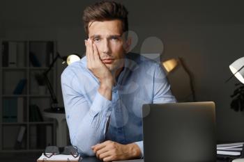 Stressed young man at workplace late in evening�