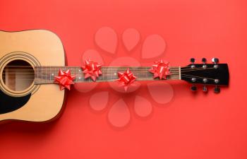 Guitar and Christmas decor on color background�