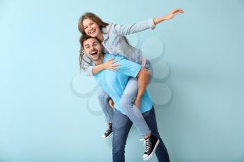 Happy young couple having fun on color background�