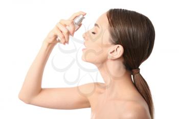 Woman applying serum onto her face against white background�