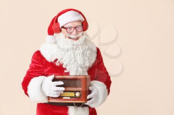 Portrait of Santa Claus with retro radio receiver on light background�
