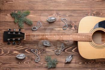 Guitar and Christmas decor on wooden background�