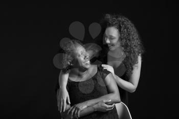 Black and white portrait of African-American woman with her daughter on dark background�