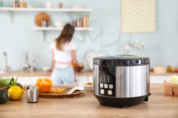 Modern multi cooker and products on kitchen table�