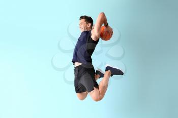 Jumping basketball player on color background�