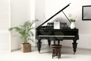 Black grand piano in interior of room�