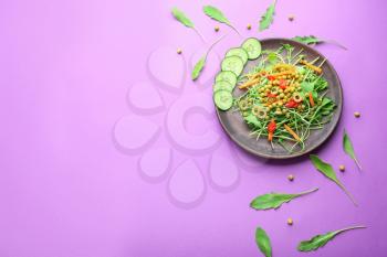 Plate with tasty arugula salad on color background�