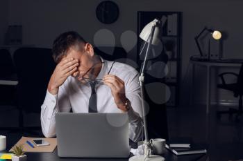 Stressed man at workplace late in evening�