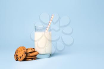 Glass of fresh milk and cookies on color background�