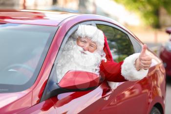 Santa Claus showing thumb-up gesture while driving car�