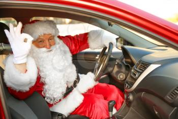 Santa Claus showing OK gesture while driving car�