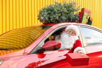 Santa Claus giving Christmas gift while sitting in car�