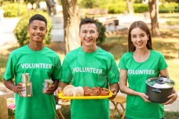Young volunteers with food for poor people outdoors�