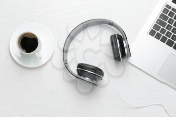 Modern headphones, laptop and cup of coffee on white background�