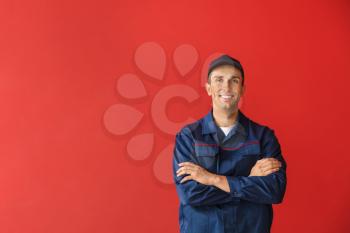 Male car mechanic on color background�