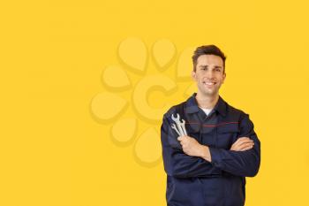 Male car mechanic on color background�